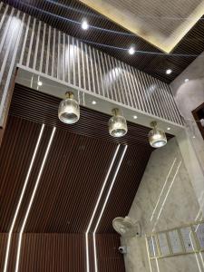 a bathroom with three lights hanging from the ceiling at Hotel Ramay Palace in Ayodhya