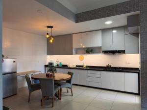 a kitchen with white cabinets and a wooden table at Reizz Residence Majesty Suite in Kuala Lumpur