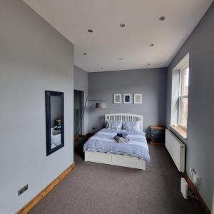 ライドにあるApartment 4 The Old Drill Hallの青い毛布が掛けられたベッドのある寝室 +4枚の写真