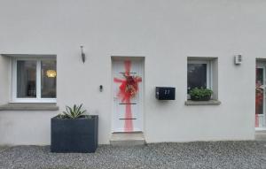 a white building with a door with a wreath on it at Jolie Maison in Pornic