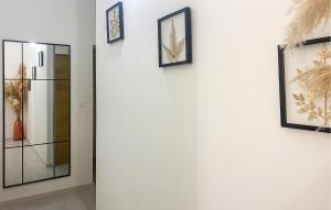 a hallway with four pictures on a white wall at Jolie Maison in Pornic