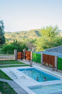 ein Pool in einem Hinterhof mit zwei Personen darin in der Unterkunft Complejo Montana in Potrero de Garay
