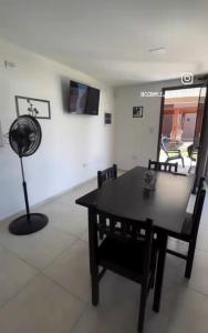 ein Esszimmer mit einem Tisch, Stühlen und einem Ventilator in der Unterkunft Complejo Montana in Potrero de Garay + 6 Fotos