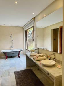 a bathroom with two sinks and a bath tub at Hala Luxury Domain in Marrakech