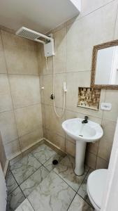 a bathroom with a sink and a toilet and a mirror at Hotel Nils in Itapoa