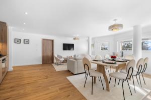 a white living room with a table and chairs at Le Belvedere By Alaïa in Crans-Montana