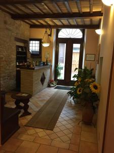a living room with a stone fireplace and a kitchen at Hotel Ristorante Il Cavaliere in Camerino