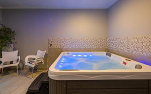 a large bath tub in a room with chairs at Serene Summer Oasis - Pool, Jacuzzi, Sauna, Sea View - Lara in Drenje