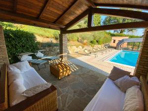 a patio with two beds and a swimming pool at Villa Beatrice - Private Heated Pool & Amazing Umbrian Landscape in Corgna