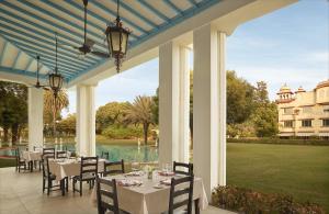 a dining room with tables and chairs on a patio at Jai Mahal Palace in Jaipur