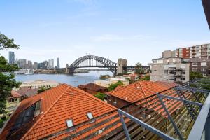 a view of the sydney harbour bridge from the roofs of buildings at Breathtaking Sydney Harbour view condo in Sydney
