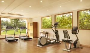 a gym with cardio equipment in a room with windows at Jai Mahal Palace in Jaipur