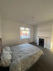 une chambre avec un lit et une cheminée dans l'établissement Garden Street Retreat in Wigston, à Glen Parva 3 autres photos