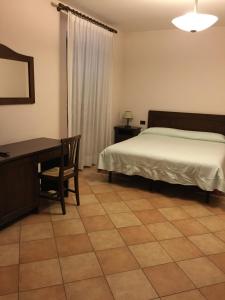 a bedroom with a bed and a desk and a table at Hotel Ristorante Il Cavaliere in Camerino