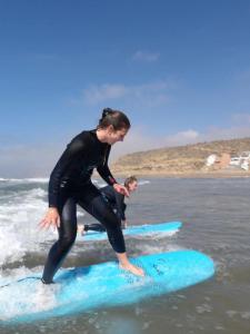 a woman and a child on surfboards in the ocean at Future in Taghazout