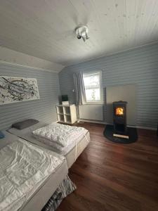 a bedroom with a bed and a wood stove at Trollforsen Camping & Cottages in Gargnäs