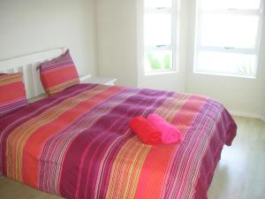 a bedroom with a bed with two pink pillows on it at Waterside Living MM1297 in Jeffreys Bay