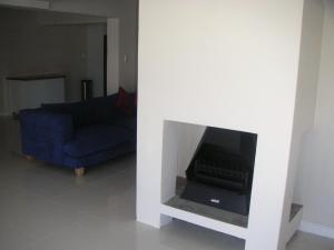 a living room with a blue couch and a fireplace at Waterside Living MM1297 in Jeffreys Bay