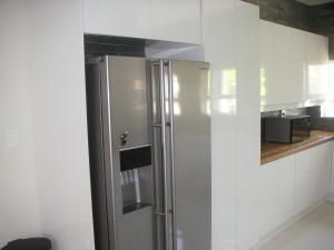 a stainless steel refrigerator in a kitchen with white cabinets at Waterside Living MM1297 in Jeffreys Bay