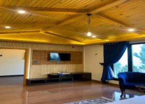 Royal Luxus في Nathia Gali: غرفة معيشة مع أريكة وتلفزيون على الحائط