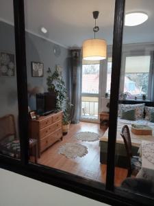 a reflection of a living room with a mirror at Apartament Dobre Miejsce in Malbork