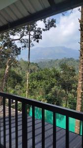 balcón con vistas a las montañas y a los árboles en Zira Homestay, en Munnar