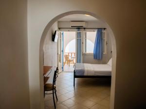 a bedroom with a bed and a room with a window at Dafnis Koufonisia in Koufonisia
