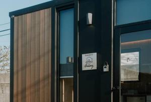 a building with a black door with a sign on it at Fulu Dragon Boat Camping House 2 by Tiny Away in Ch'iao-t'ou +5 photos