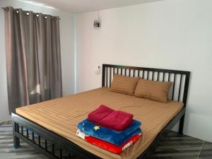 a bed with two pillows on it in a room at Maloop Cafe Hostel in Koh Rong Island