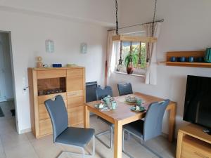 a dining room with a table and chairs and a television at Appartement Auszeit in Olsberg
