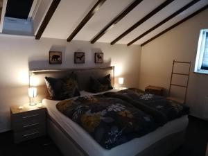 a bedroom with a large bed and two lamps at Appartement Auszeit in Olsberg
