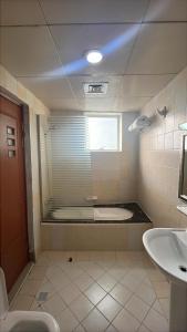 a bathroom with a toilet and a sink and a window at Clifton International Hotel in Fujairah