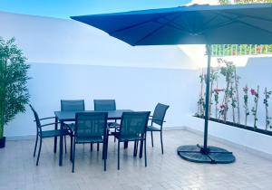a blue table and chairs with a blue umbrella at Villa Bleue Agadir climatisée-centre-3chambres in Agadir