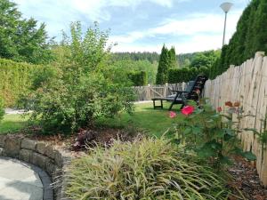 a garden with a bench next to a fence at Appartement Auszeit in Olsberg +6 photos