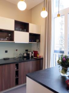 a kitchen with a black counter top and a window at Design Marais Temple CityCosy in Paris