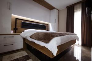 ein Schlafzimmer mit einem großen Bett und einem Fenster in der Unterkunft Vila Sofija Banja Vrujci in Gornja Toplica