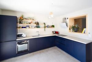 una cucina con mobili blu e un lavandino di Villa Rethel avec piscine - dans le centre de Montpellier a Montpellier