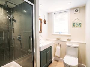 ein Badezimmer mit Dusche, Toilette und Waschbecken in der Unterkunft Cannon Corner by The Suffolk Cottage Collection in Aldeburgh