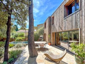 un cortile con tavolo, sedie e alberi di Villa Rethel avec piscine - dans le centre de Montpellier a Montpellier