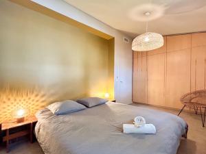 una camera da letto con un letto grande con asciugamani sopra di Villa Rethel avec piscine - dans le centre de Montpellier a Montpellier