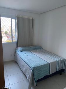 a bedroom with a bed in a white room with a window at Apartamento exclusivo COP 30 in Belém