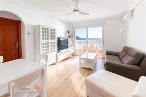 a living room with a couch and a table at Apartamentos Turisticos Isla Grosa in La Manga del Mar Menor