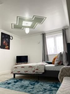 a bedroom with a bed and a television in it at Stanton - Stylish 2 Bedroom in Dagenham