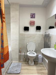 a bathroom with a toilet and a sink at Stanton - Stylish 2 Bedroom in Dagenham