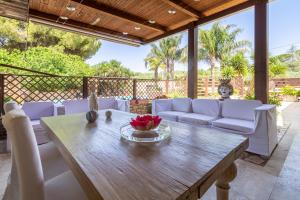 sala de estar con mesa de madera y muebles blancos en Ap in Villa Giusa, en Caltagirone