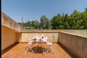Una mesa y dos sillas en un balcón. en Ap in Villa Giusa, en Caltagirone