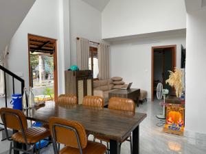 a living room with a wooden table and chairs at T-House Homestay Tiền Giang in Bến Tranh