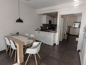 a kitchen and dining room with a wooden table and chairs at City Apartment 221 in Merano +21 photos