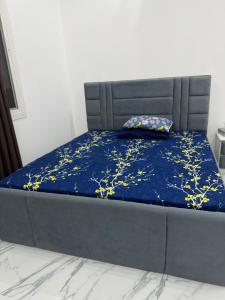 un letto con un piumone blu e fiori sopra di Homestay Private Room with attached washroom in Villa in Ajman ad Ajman