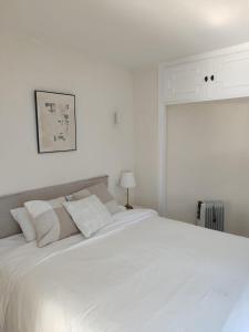 ein weißes Schlafzimmer mit einem großen weißen Bett in der Unterkunft Pinos de Calahonda duplex in Sitio de Calahonda